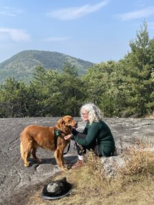 Happy, the red golden retriever with Julie the author of Happy and me blog on a summit in the Adirondack