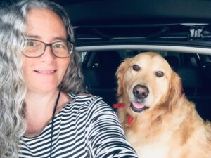 Woman in her stripes french shirt with golden retriever siting by her with his red scarf